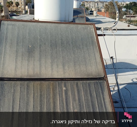 דוד שמש על גג עם צינורות וחיבורים